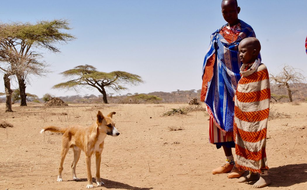 Woman and child standing next to dog