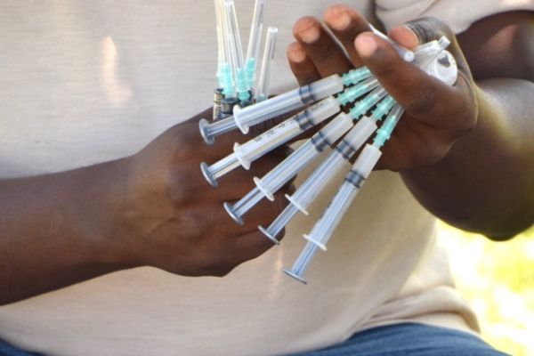 Vaccine Effectiveness Man with hand full of vaccines